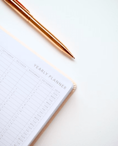 pen and yearly planner on white table