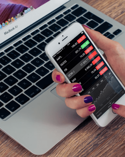 Person holding iphone 6 with stocks on the screen
