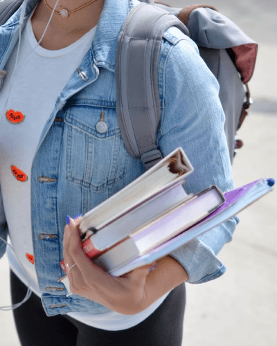 Student holding a stack of books