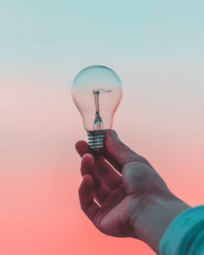 Person holding a lightbulb in the sunset
