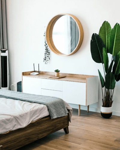 white wooden dress with mirror across from a bed